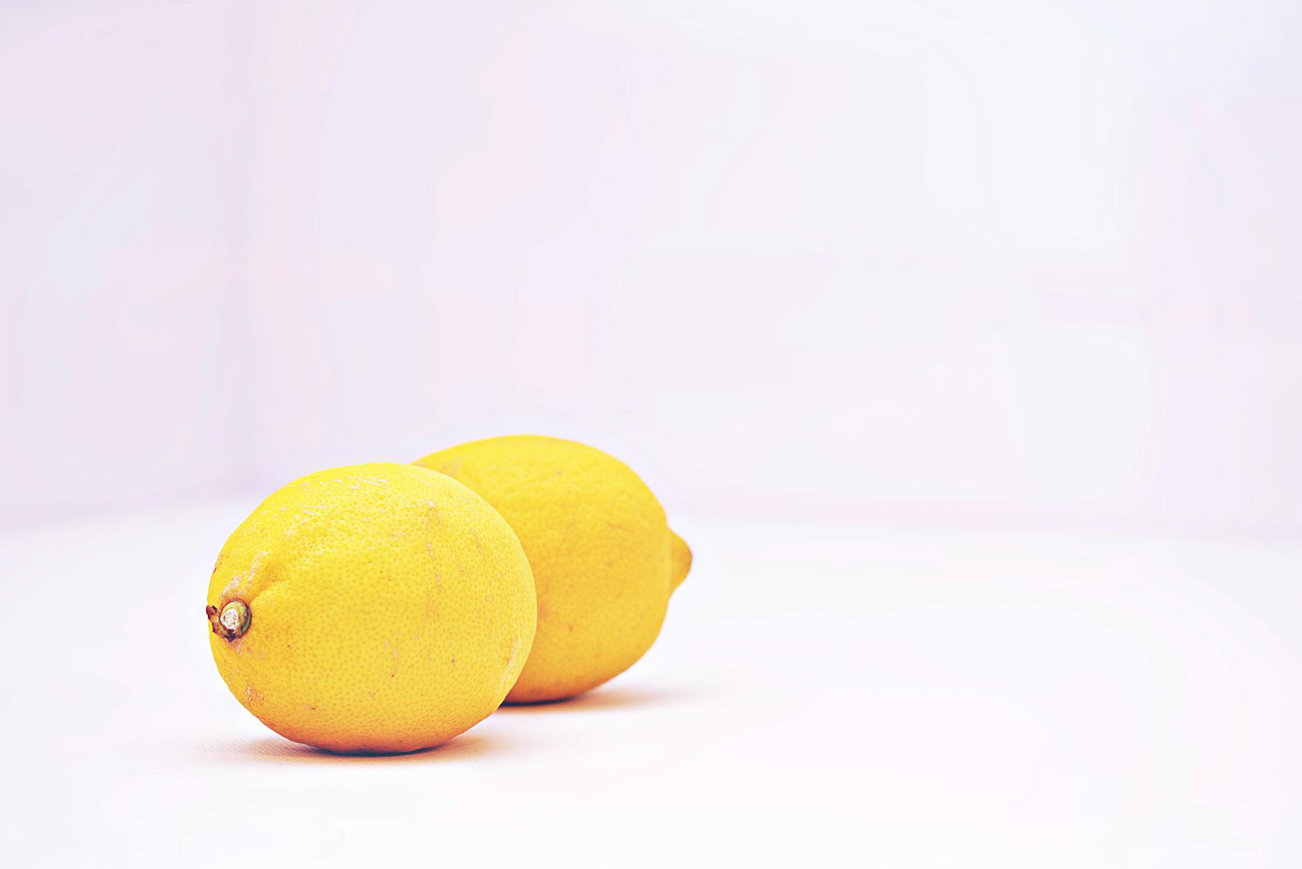 Two bright lemons on a clean white background, symbolizing clarity and fresh perspectives on intimacy
