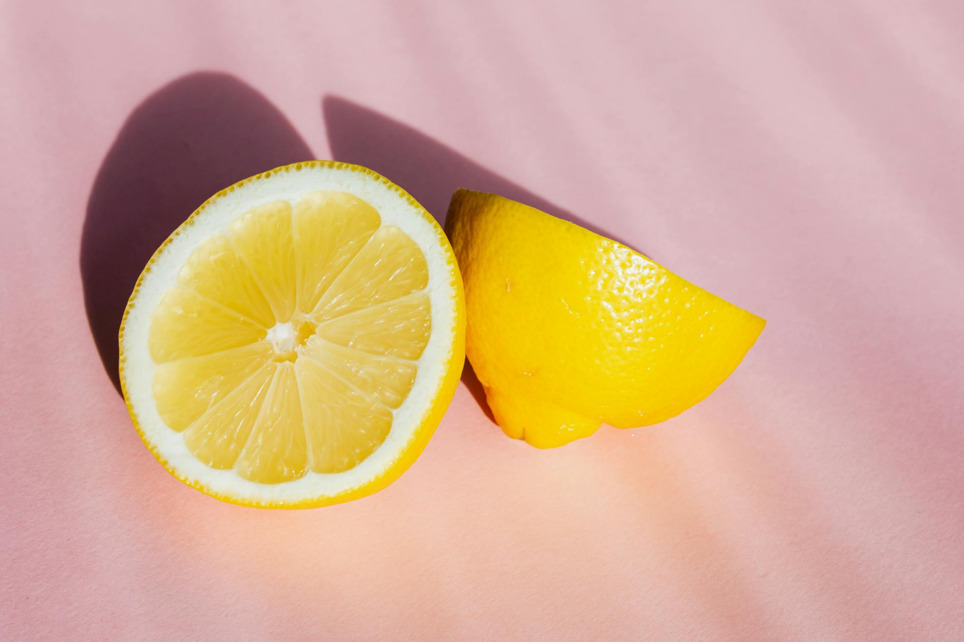 Limones frescos y maduros en fila sobre un fondo pastel, simbolizando la renovación del ciclo