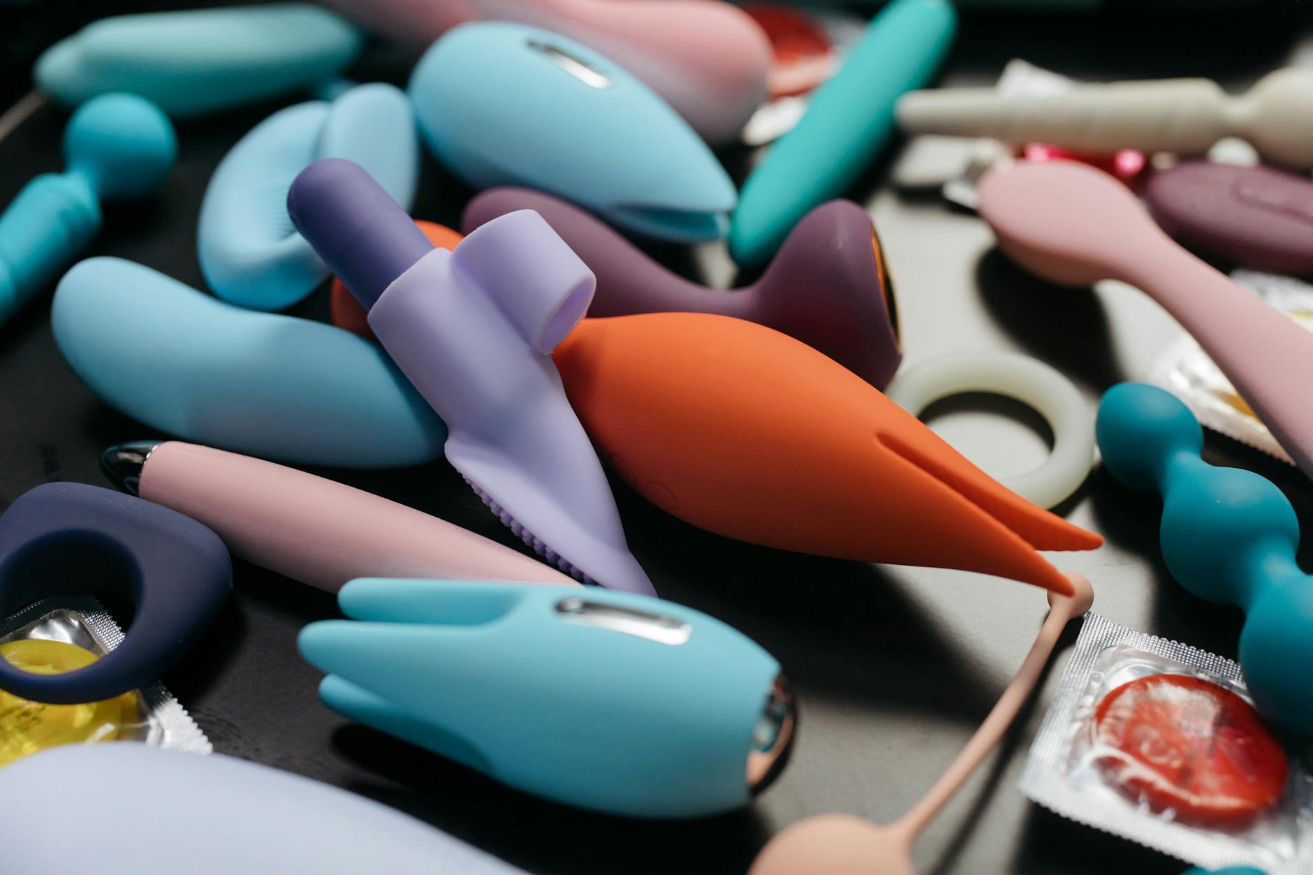 Colección de juguetes sexuales de colores vibrantes incluyendo vibradores en vista cercana