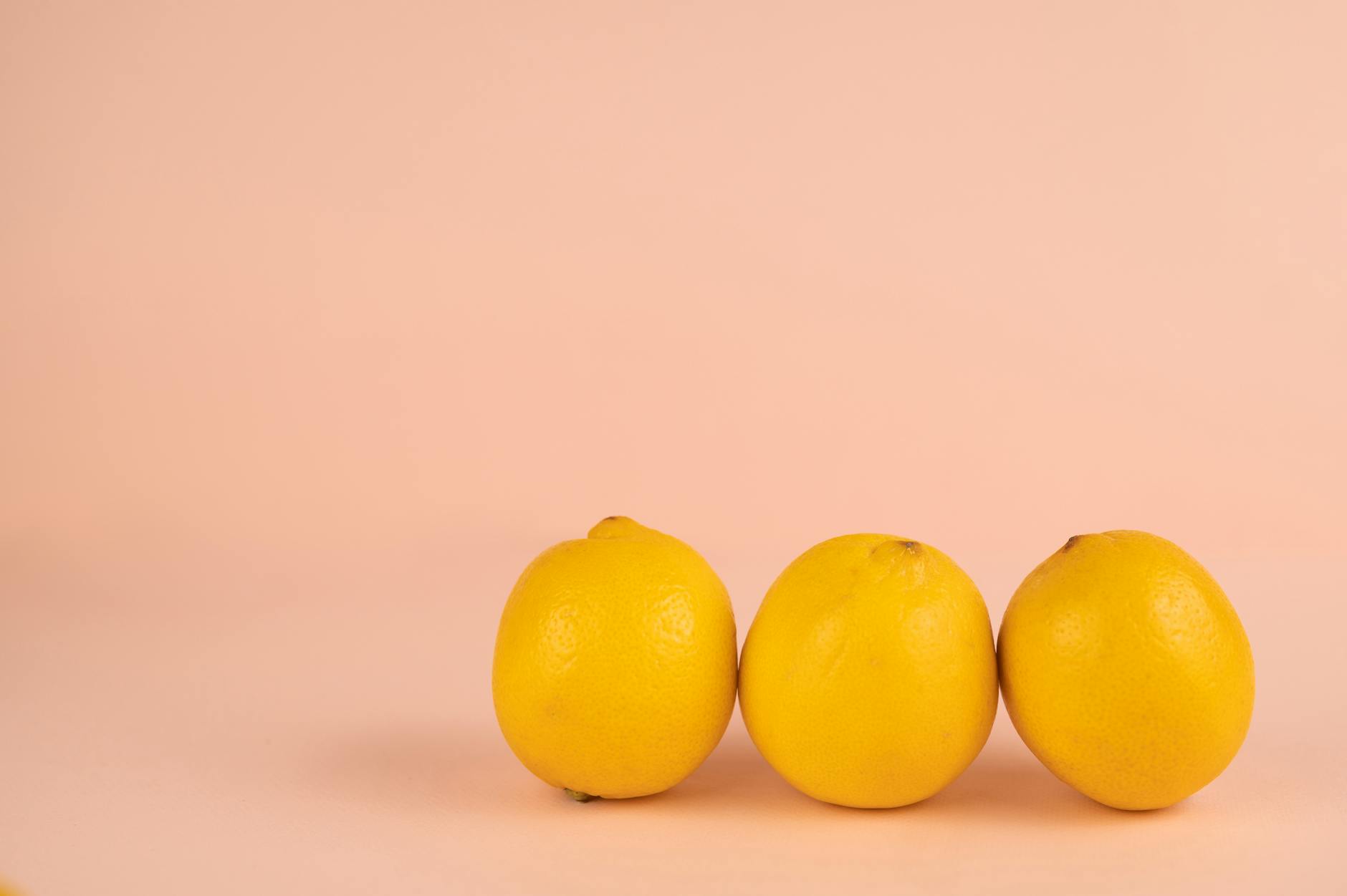 Mano sosteniendo un vibrador naranja moderno contra un fondo minimalista de color púrpura